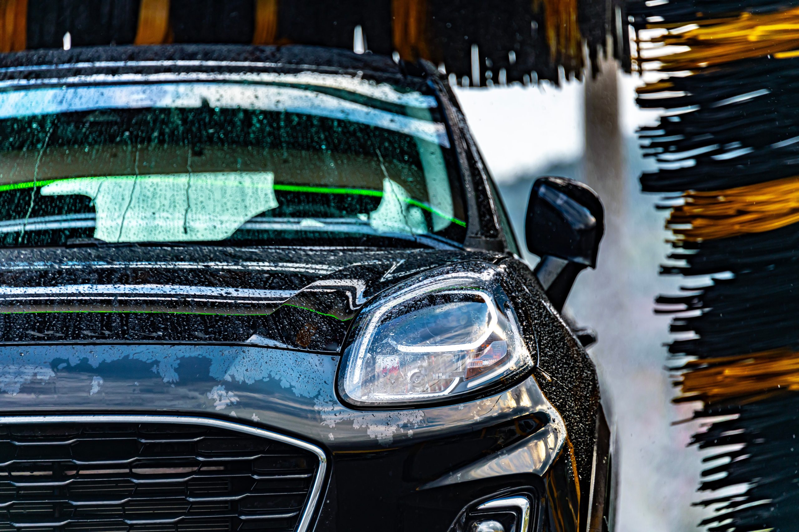 A,Vehicle,In,An,Automatic,Car,Wash. A car going through an automatic car wash