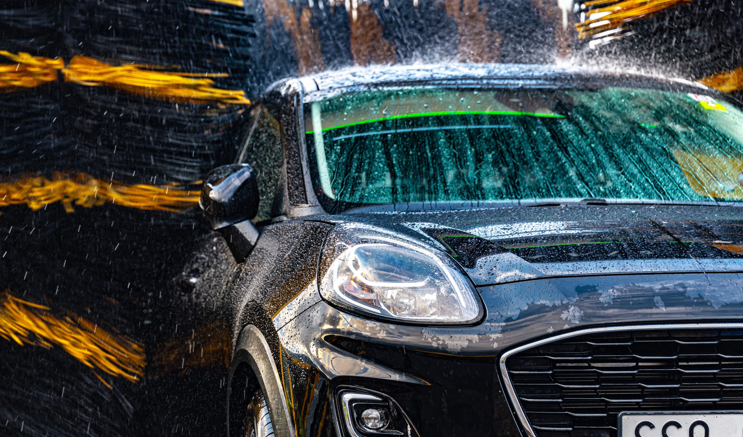 A,Vehicle,In,An,Automatic,Car,Wash. A car going through an automatic car wash